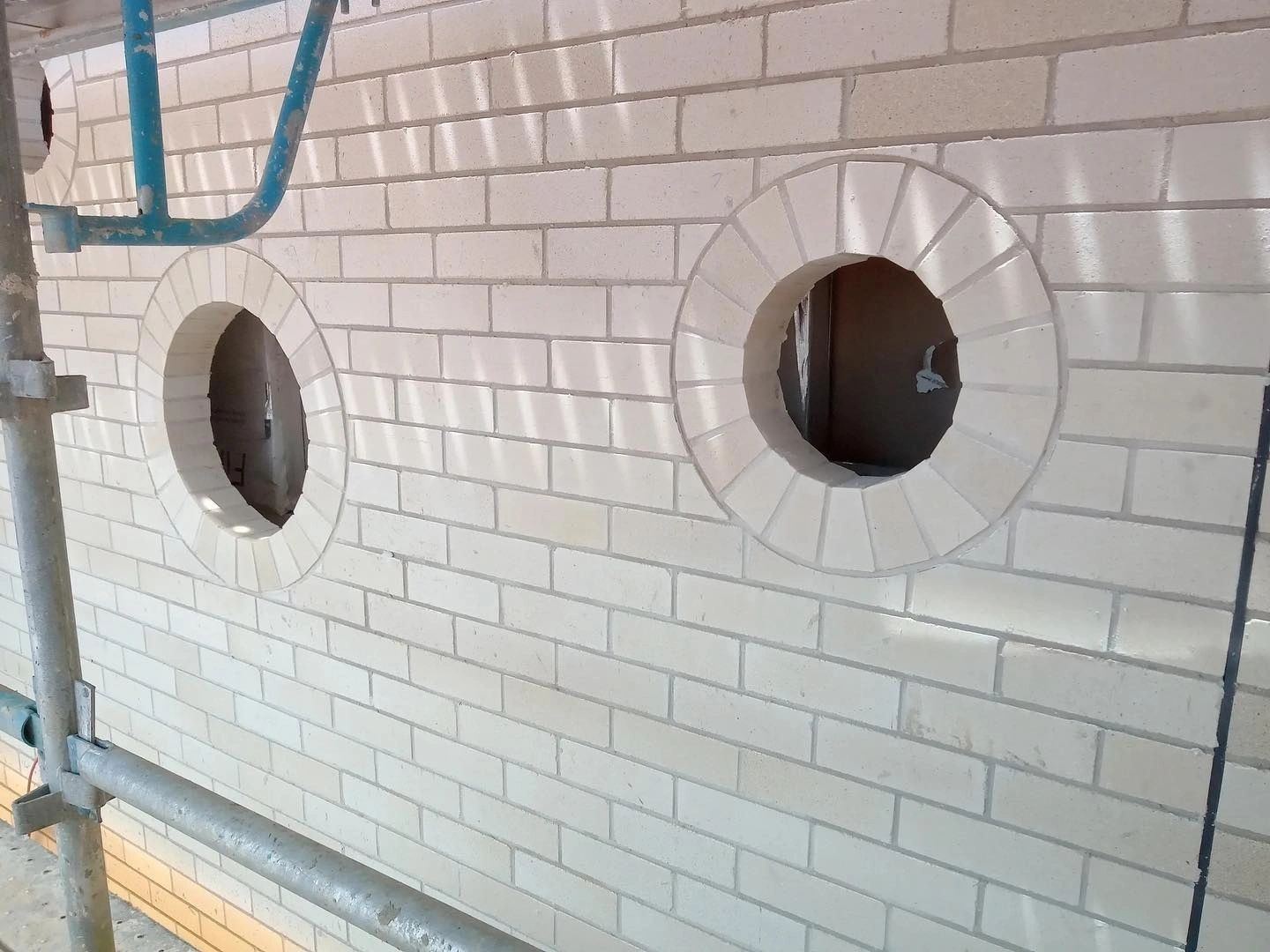 New face brickwork with arched brick surrounds on porthole windows